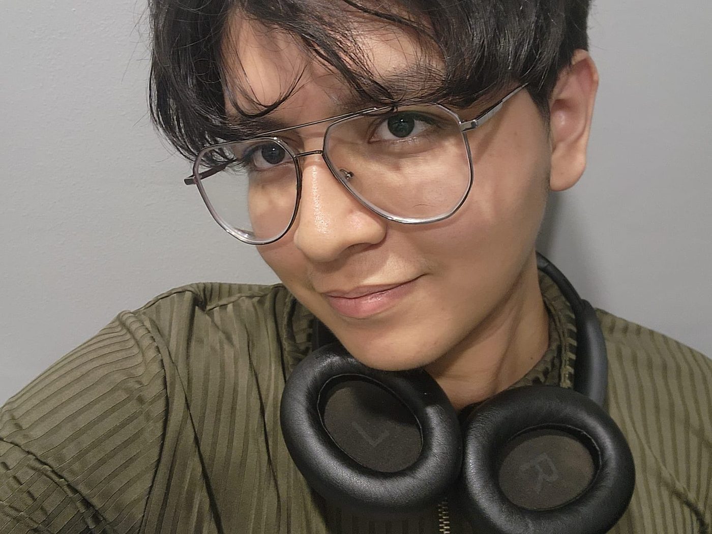 Selfie sonriendo con audífonos al cuello